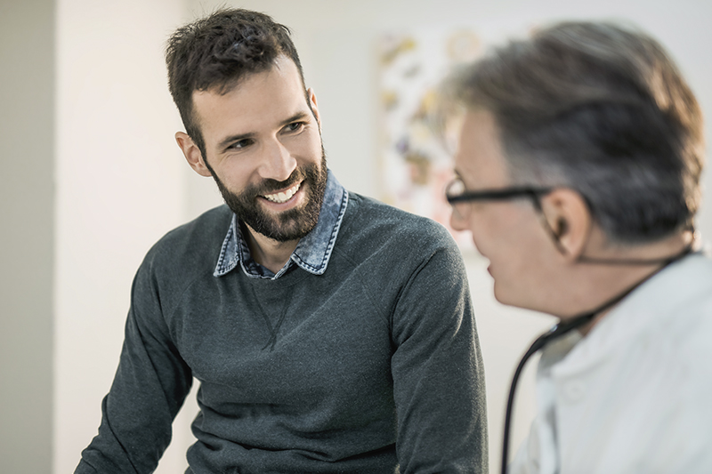 Man smiling at doctor assessing him